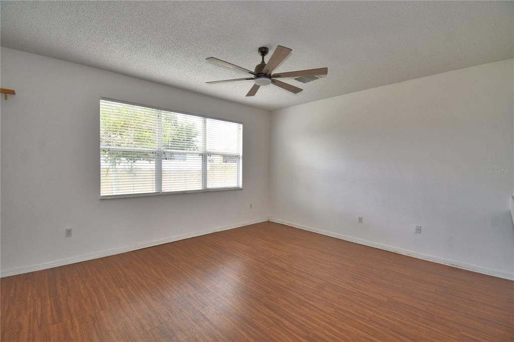154 Canna Drive Davenport, FL 33897 - Photo 37 of 85 an empty room with wooden floor fan and windows