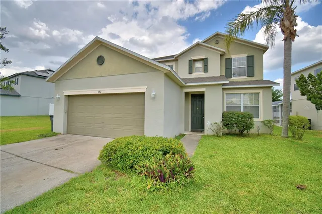 a view of a house with a backyard and a tree