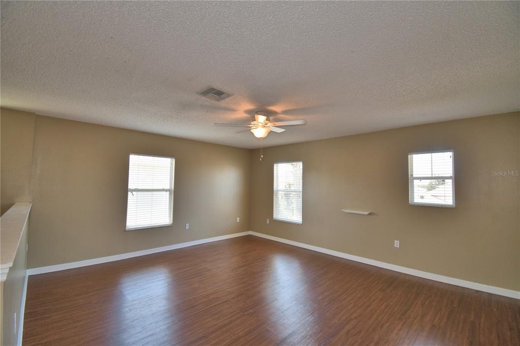 154 Canna Drive Davenport, FL 33897 - Photo 43 of 85 a view of an empty room with wooden floor and a window