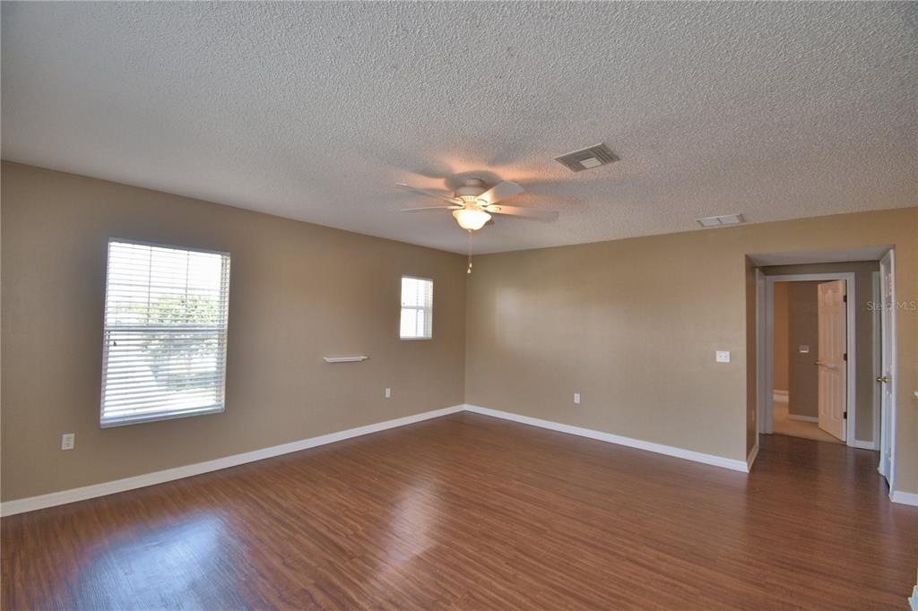 154 Canna Drive Davenport, FL 33897 - Photo 44 of 85 a view of an empty room with wooden floor and a window