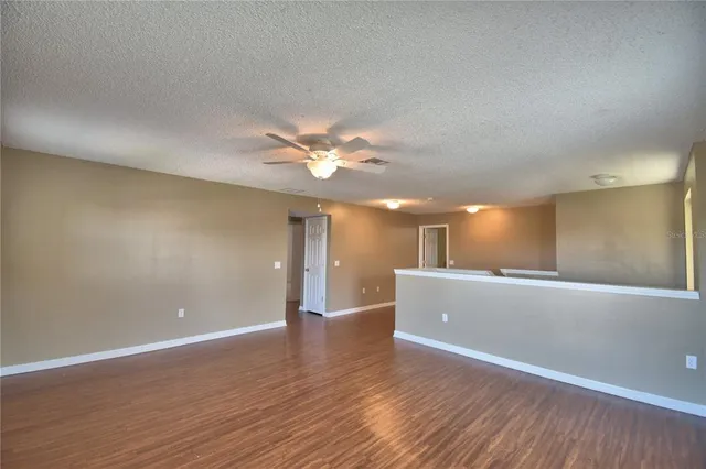 an empty room with a ceiling fan and a window