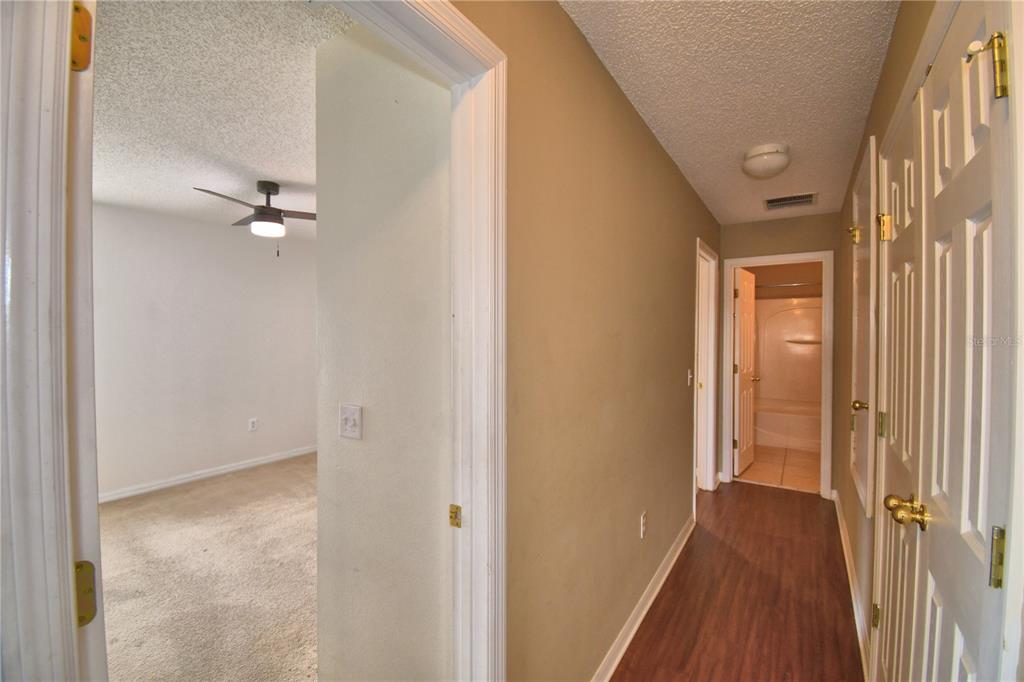 154 Canna Drive Davenport, FL 33897 - Photo 61 of 85 a view of a hallway with wooden floor and a bathroom