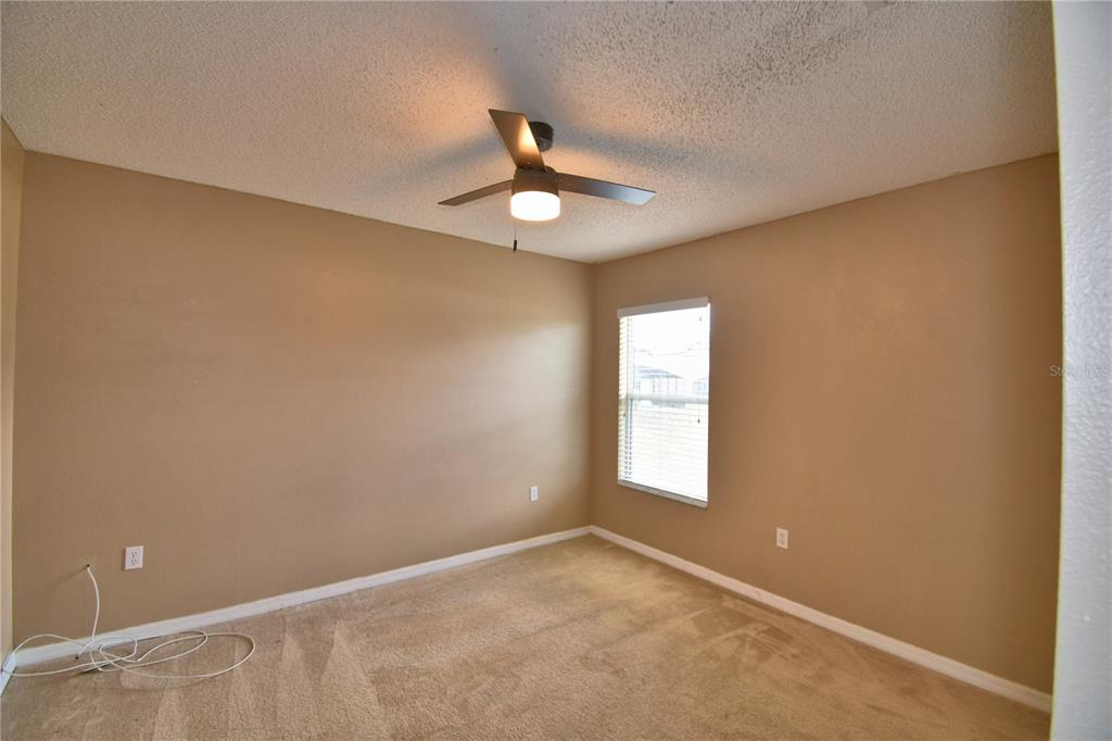 154 Canna Drive Davenport, FL 33897 - Photo 70 of 85 an empty room with a window and ceiling fan