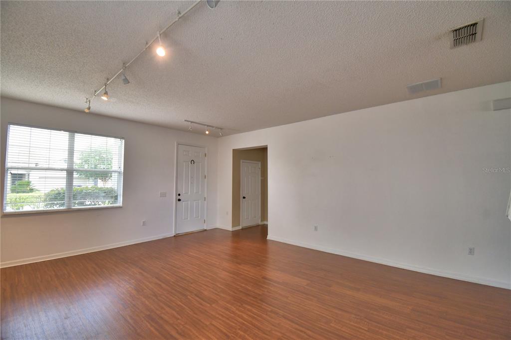 154 Canna Drive Davenport, FL 33897 - Photo 9 of 85 an empty room with wooden floor and windows