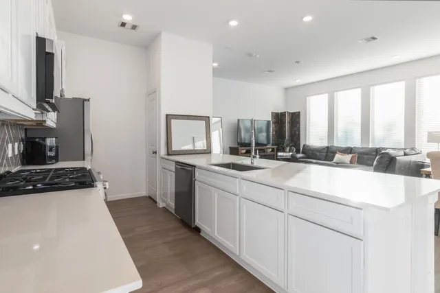 a kitchen with stainless steel appliances a sink stove and cabinets