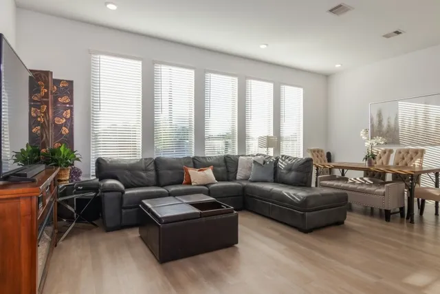 a living room with stainless steel appliances kitchen island granite countertop wooden floor and a view of kitchen