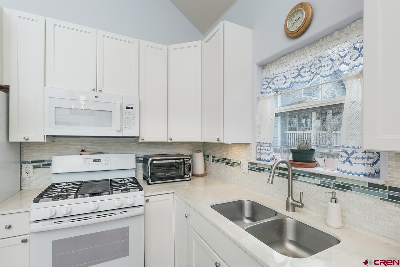 221 Jenkins Ranch Road, Unit H Durango, CO 81301 - Photo 10 of 26 a kitchen with granite countertop a sink a stove and cabinets