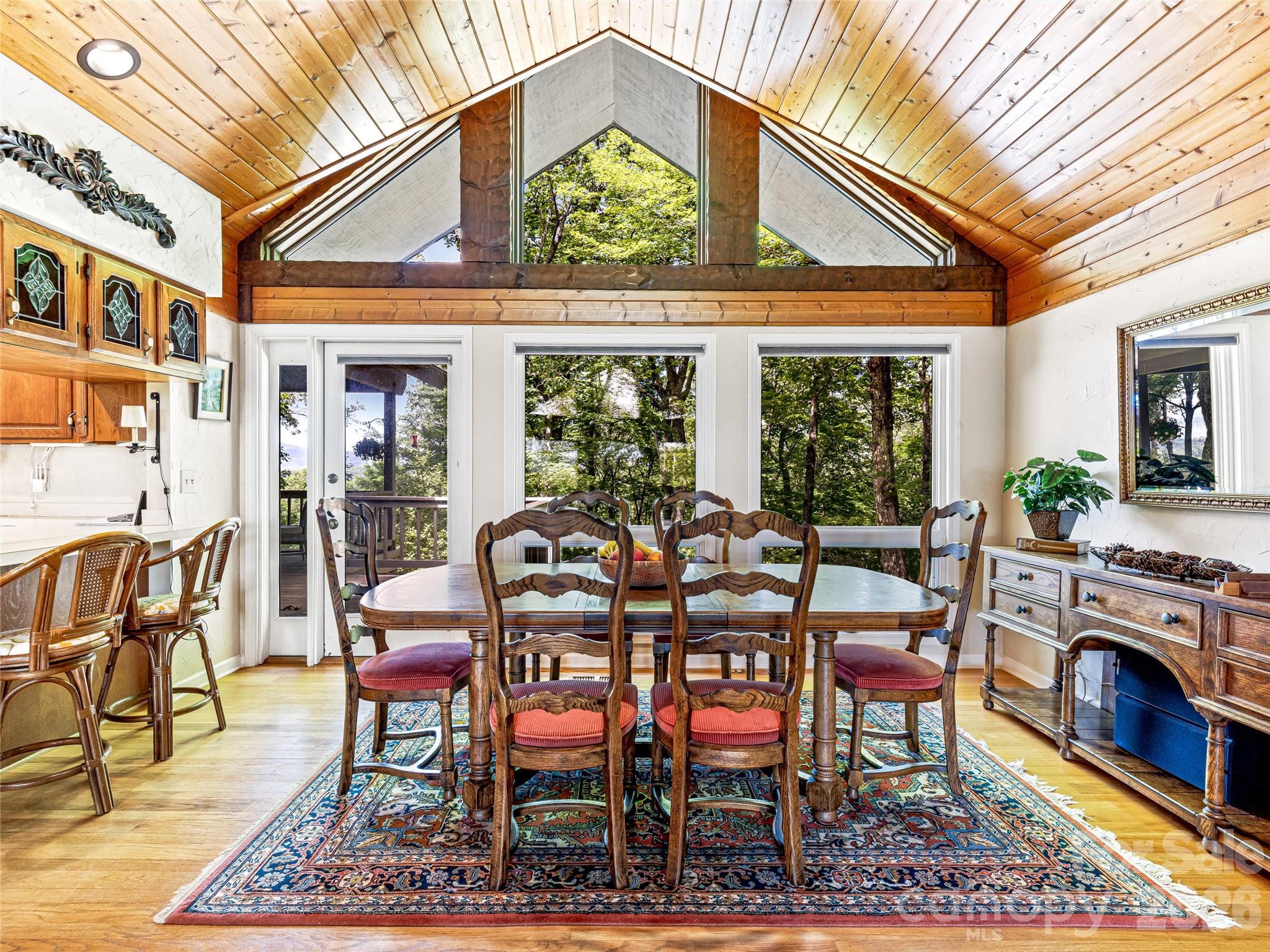 796 Hawk Mountain Road, Unit 36R Lake Toxaway, NC 28747 - Photo 12 of 39 a dining room with furniture a rug and a floor to ceiling window
