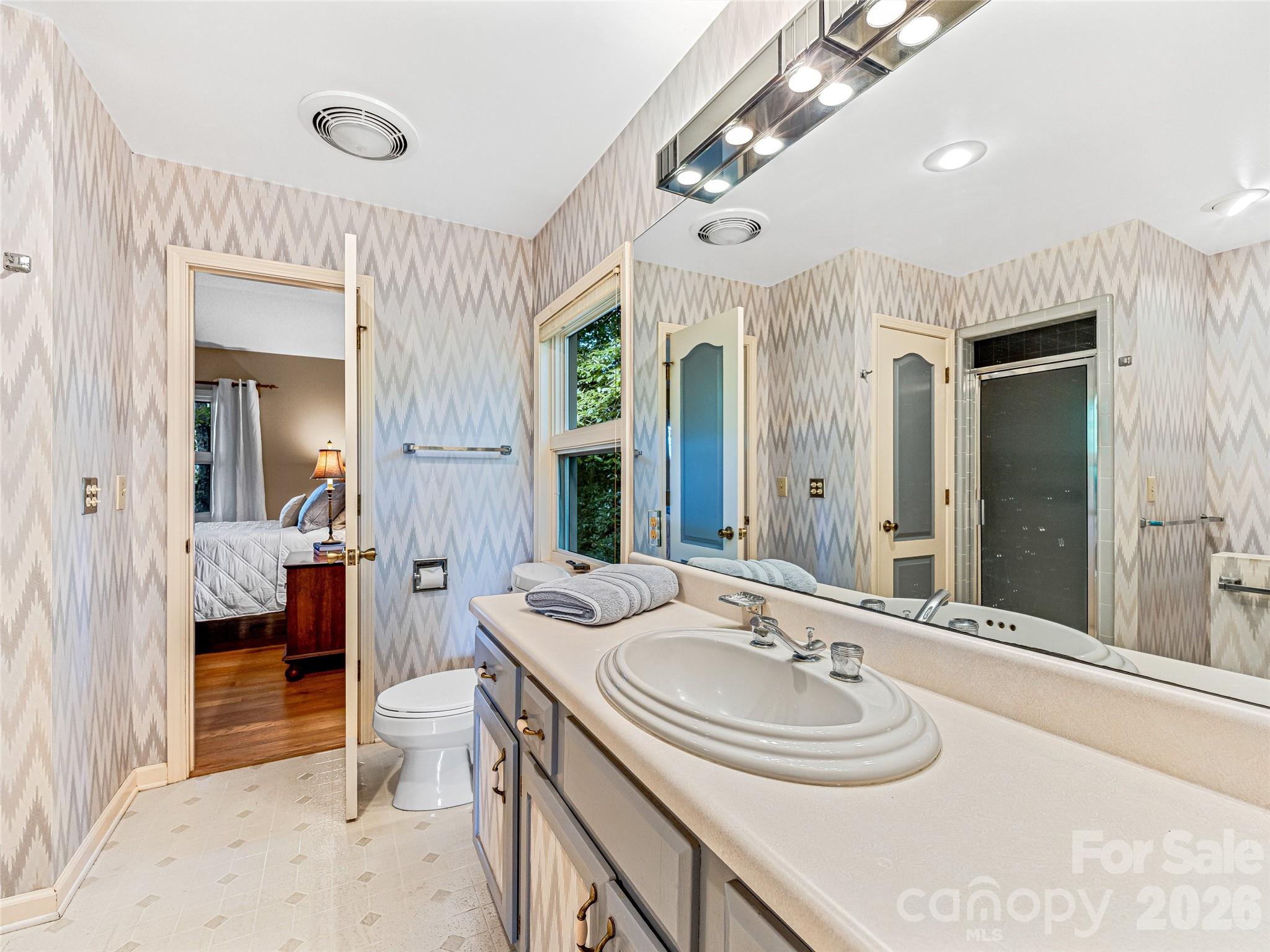796 Hawk Mountain Road, Unit 36R Lake Toxaway, NC 28747 - Photo 24 of 39 a bathroom with a sink a large mirror and a bathtub