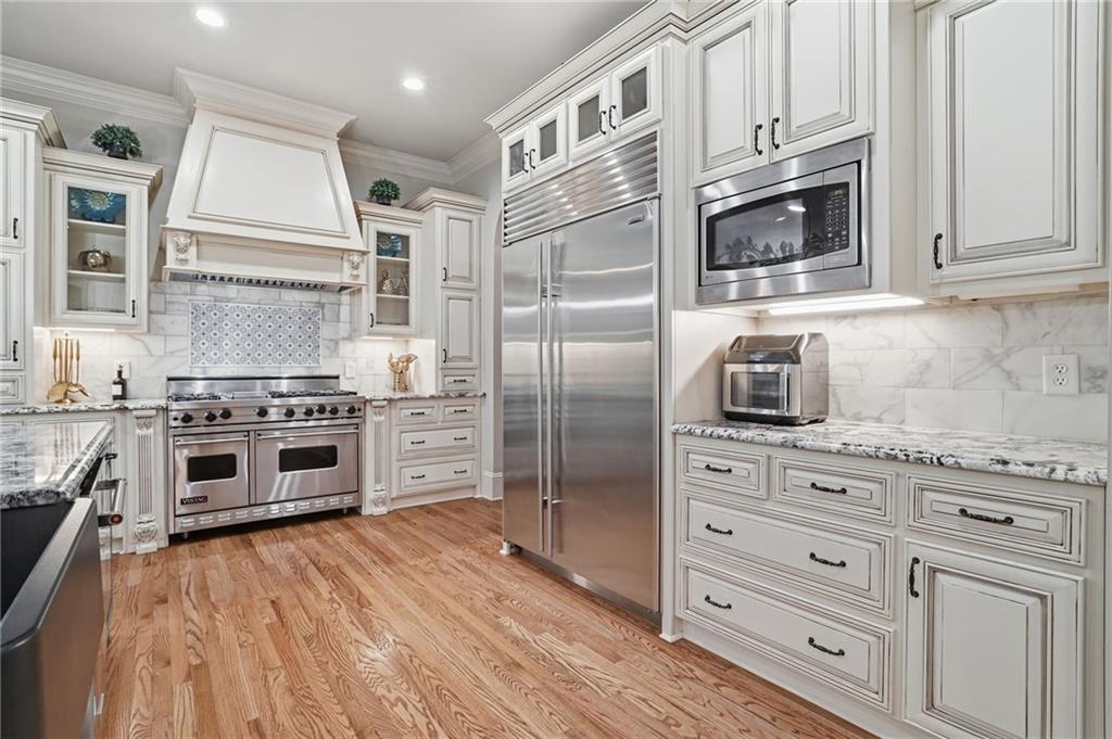 8340 Colonial Place Duluth, GA 30097 - Photo 11 of 74 a kitchen with stainless steel appliances granite countertop a stove and a refrigerator