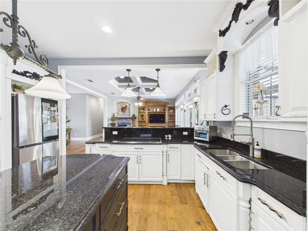 a kitchen with kitchen island a counter top space a sink stainless steel appliances and cabinets