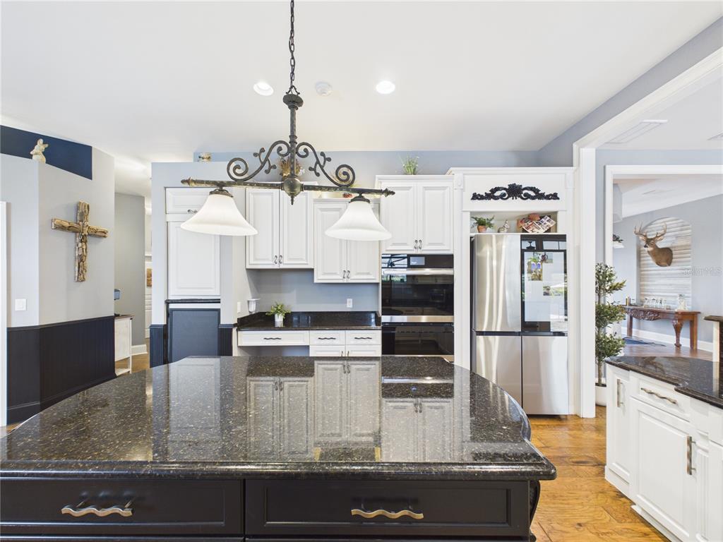 2215 Southwest 80th Street Ocala, FL 34476 - Photo 15 of 64 a kitchen with kitchen island a counter top space a sink stainless steel appliances and cabinets