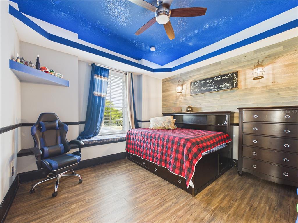 2215 Southwest 80th Street Ocala, FL 34476 - Photo 29 of 64 a living room with a bed furniture and a chandelier