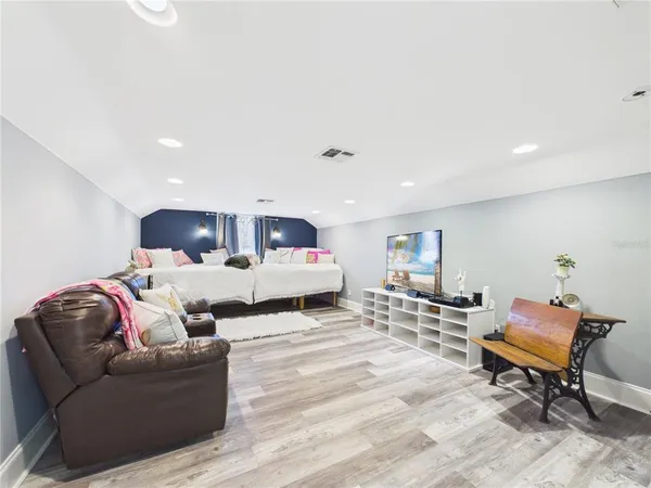 a kitchen with stainless steel appliances granite countertop a stove a refrigerator a dining table and chairs with the floor to ceiling window