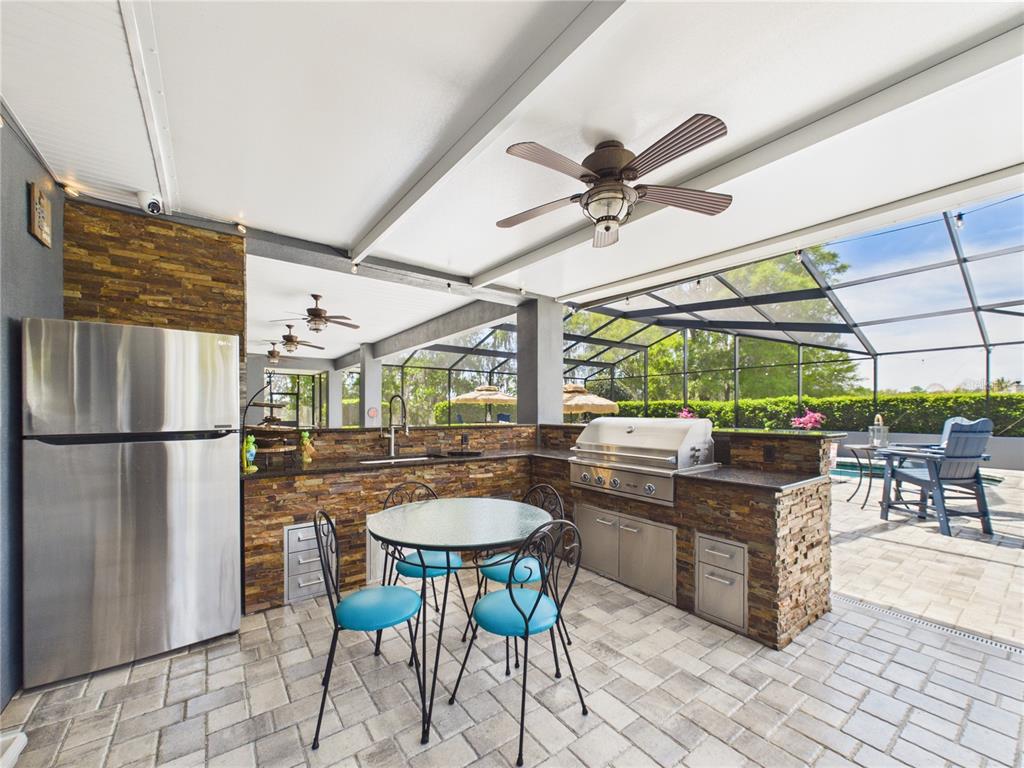2215 Southwest 80th Street Ocala, FL 34476 - Photo 43 of 64 a kitchen with stainless steel appliances granite countertop a stove a refrigerator a dining table and chairs with the floor to ceiling window