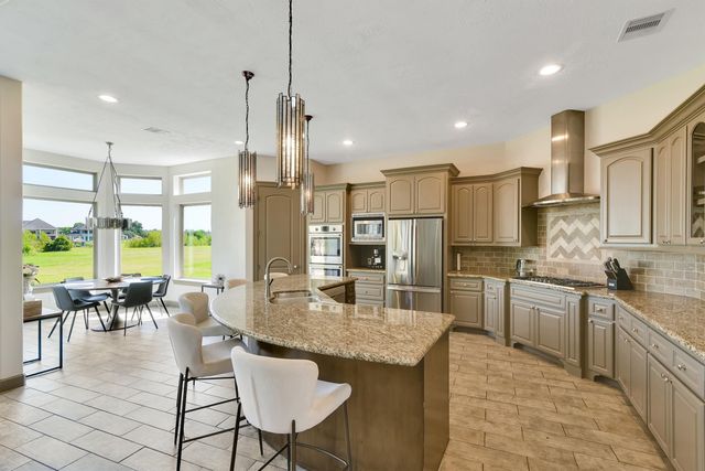 a kitchen with kitchen island granite countertop lots of counter top space and stainless steel appliances