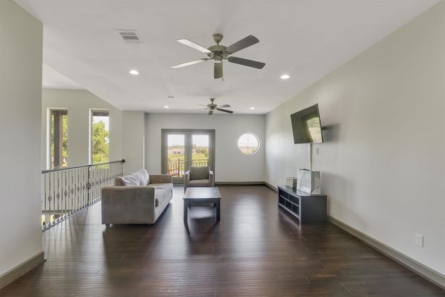 a living room with couches and a view of kitchen