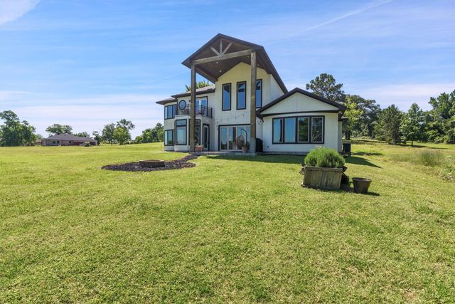 a front view of a house with a garden and trees