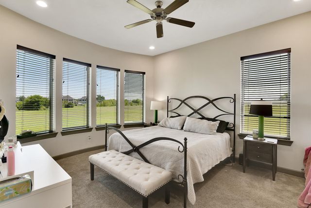 a bedroom with a bed and a large window