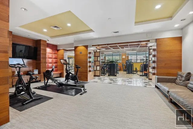 a living room with stainless steel appliances furniture and a flat screen tv