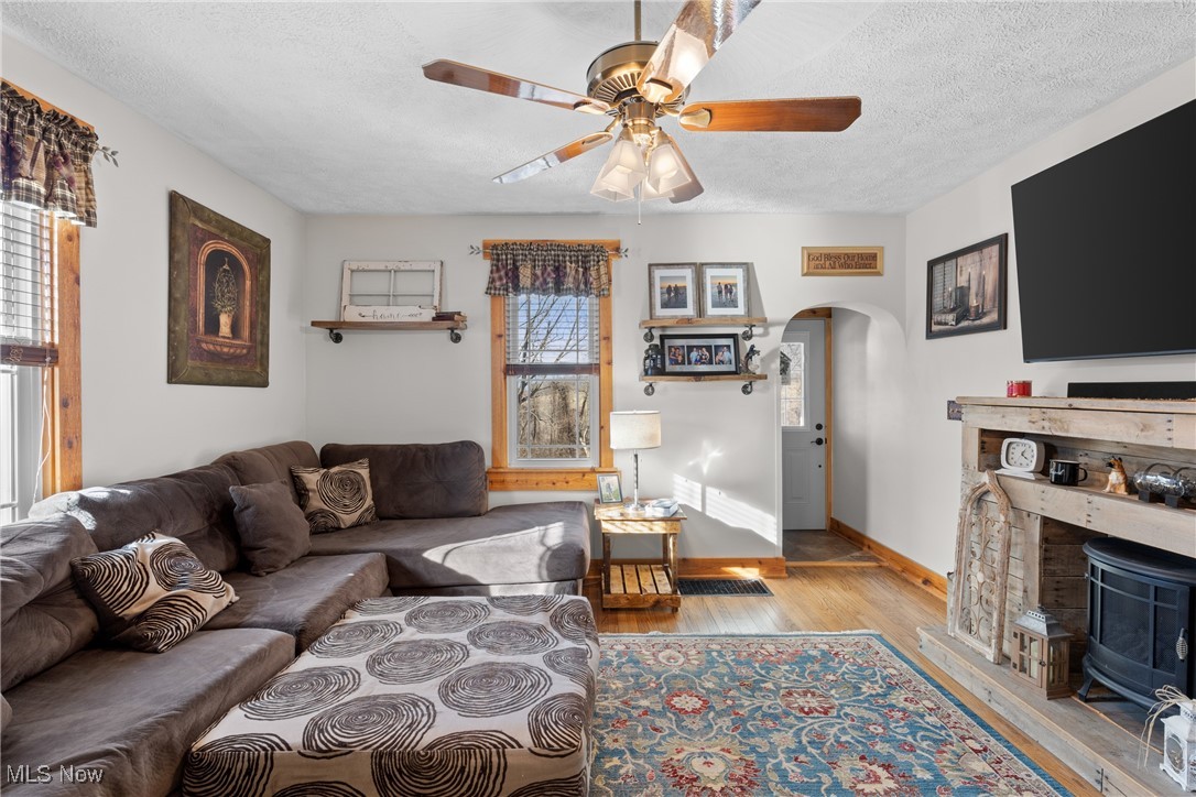 71963 W Road Martins Ferry, OH 43935 - Photo 7 of 39 Living area with arched walkways, ceiling fan, a textured ceiling, wood finished floors, and baseboards