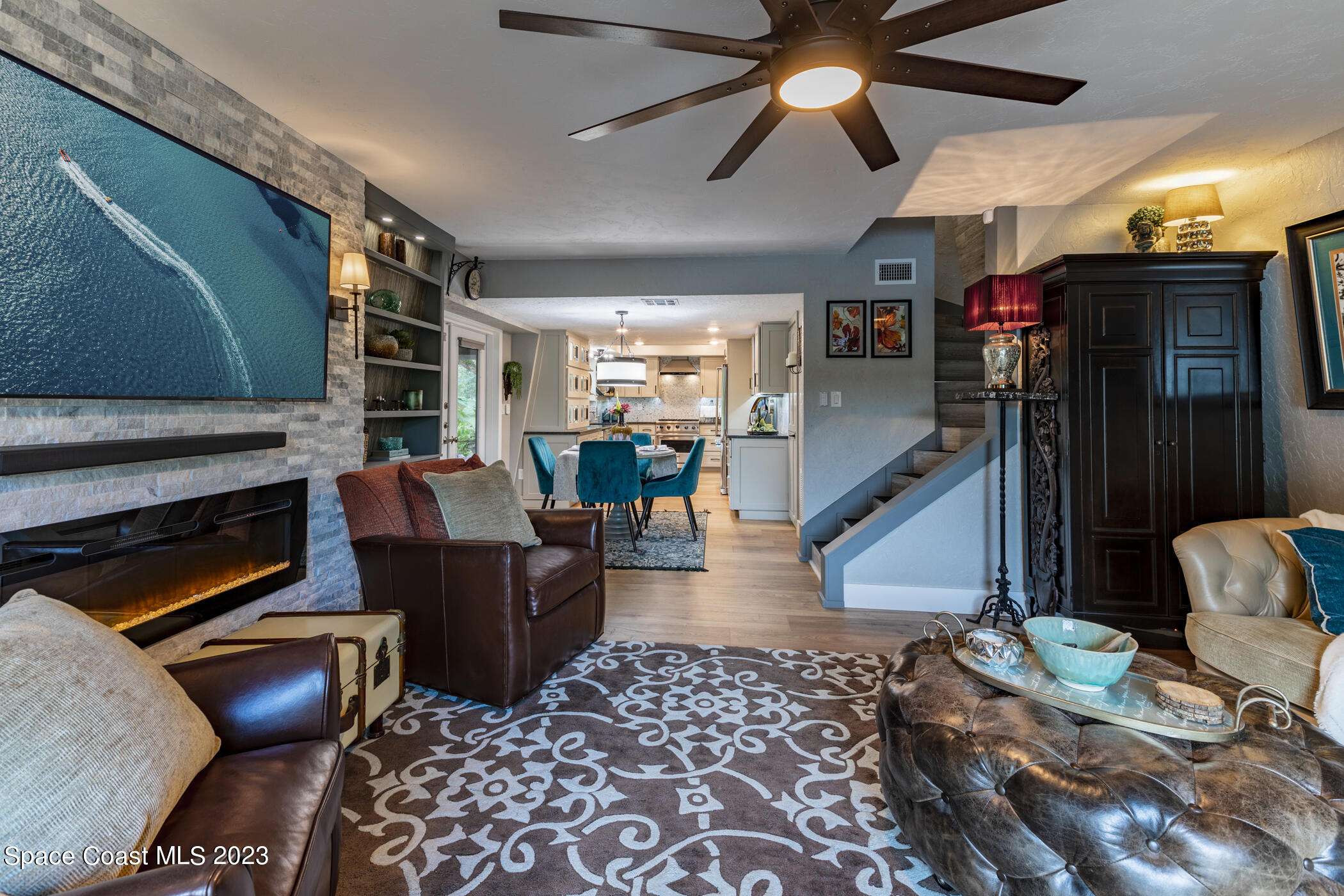 1428 Rose Court Melbourne, FL 32935 - Photo 19 of 78 a living room with furniture a flat screen tv and a fireplace