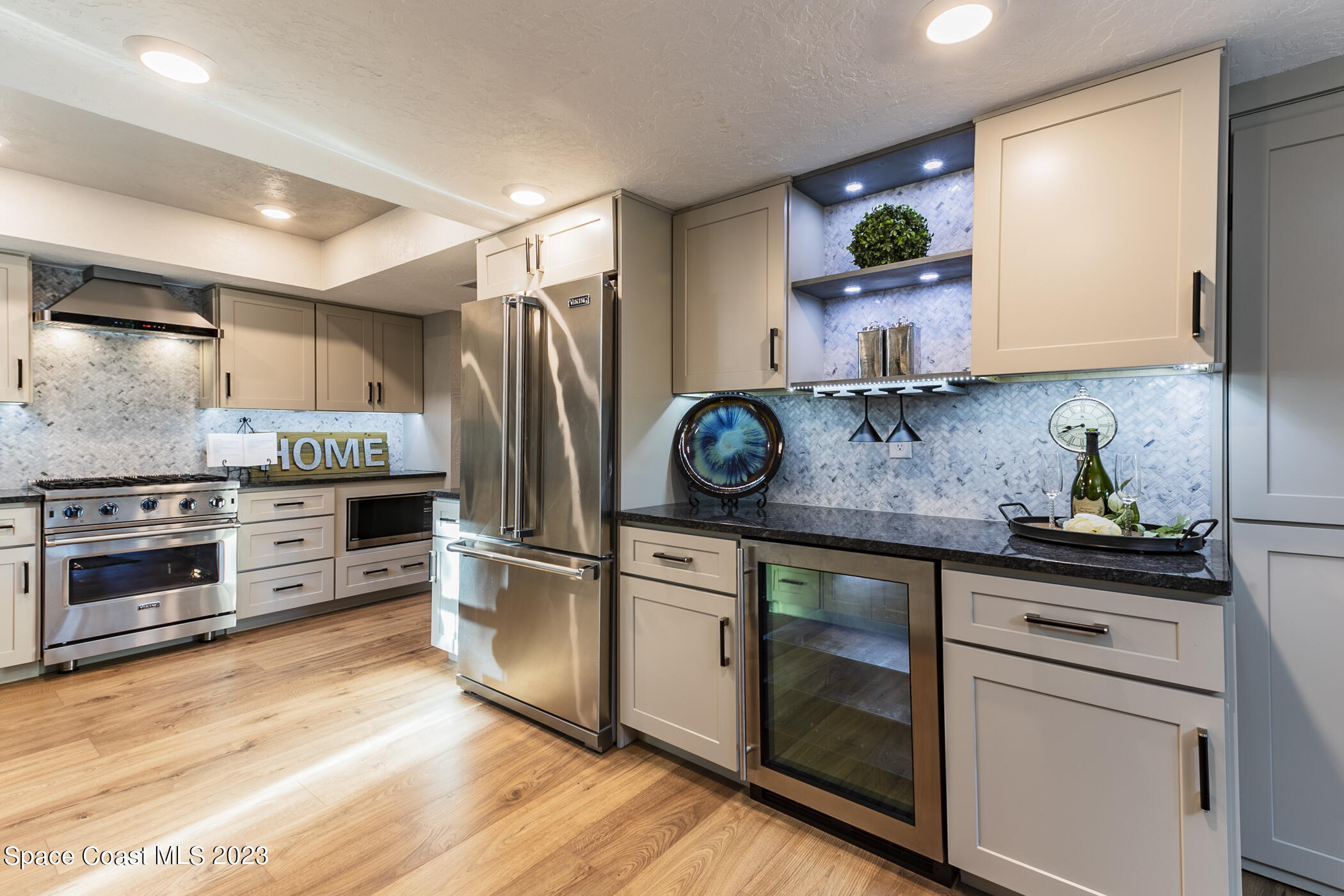 1428 Rose Court Melbourne, FL 32935 - Photo 25 of 78 a kitchen with white cabinets and stainless steel appliances