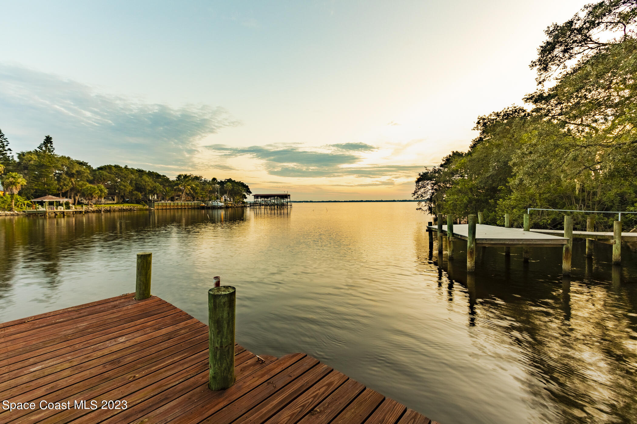 1428 Rose Court Melbourne, FL 32935 - Photo 3 of 78 a view of a lake with boats and trees in the background