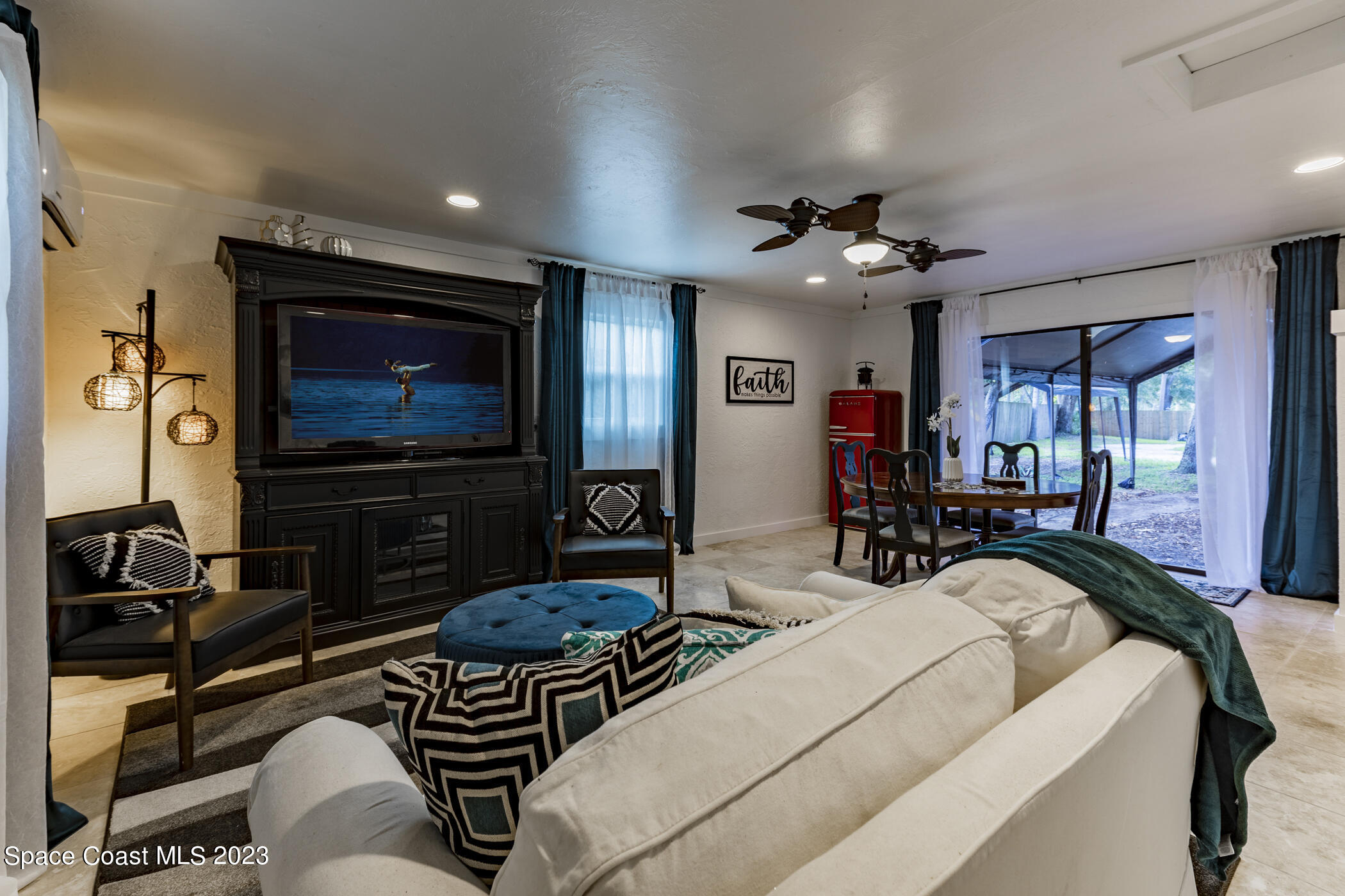 1428 Rose Court Melbourne, FL 32935 - Photo 35 of 78 a living room with furniture a flat screen tv and a ceiling fan