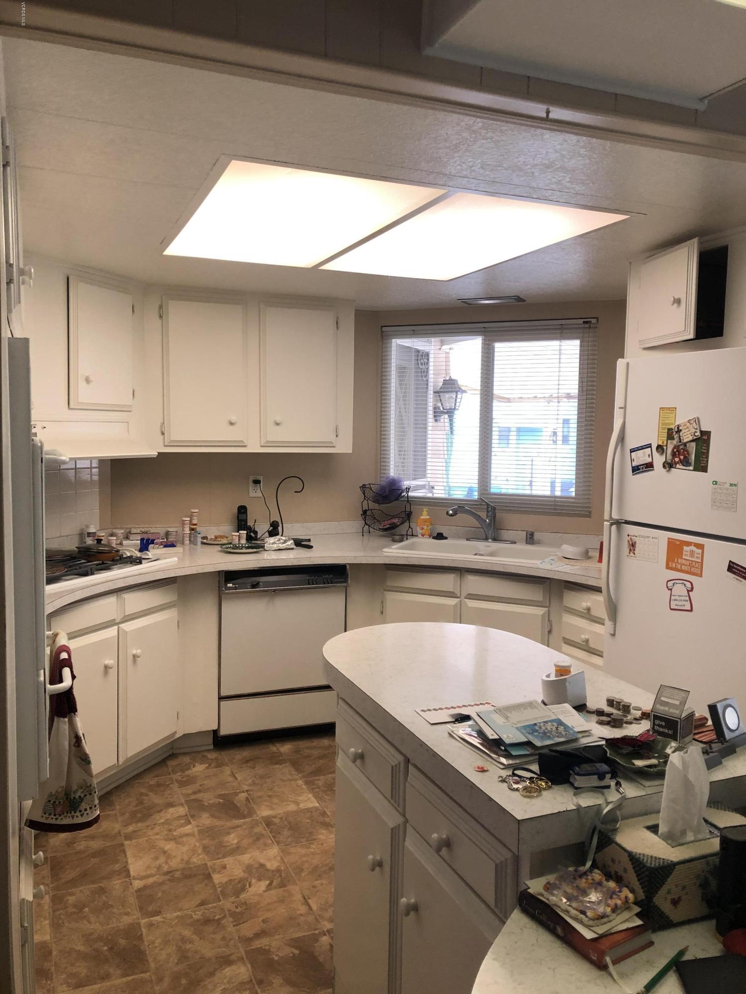 6480 Katherine Road, Unit 60 Simi Valley, CA 93063 - Photo 8 of 13 a kitchen with a stove a sink and a refrigerator