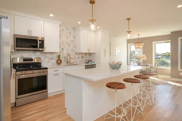 a kitchen with stainless steel appliances granite countertop a sink stove and refrigerator