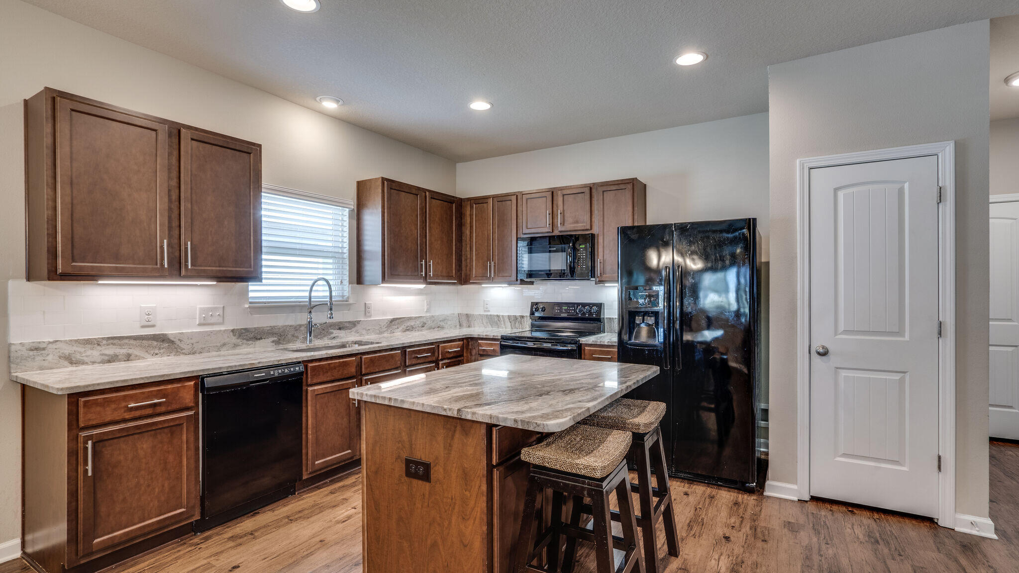 260 Cornelia Street Freeport, FL 32439 - Photo 12 of 42 a kitchen with granite countertop kitchen island stainless steel appliances a sink stove and refrigerator