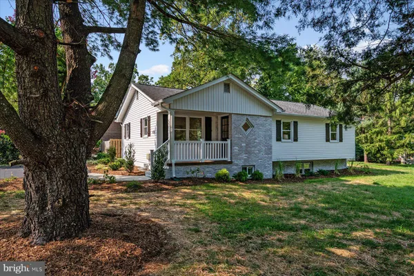 a view of a yard in front of a house with large windows