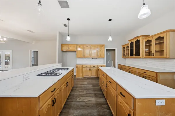 a hallway with a stove a faucet a dining table and chairs