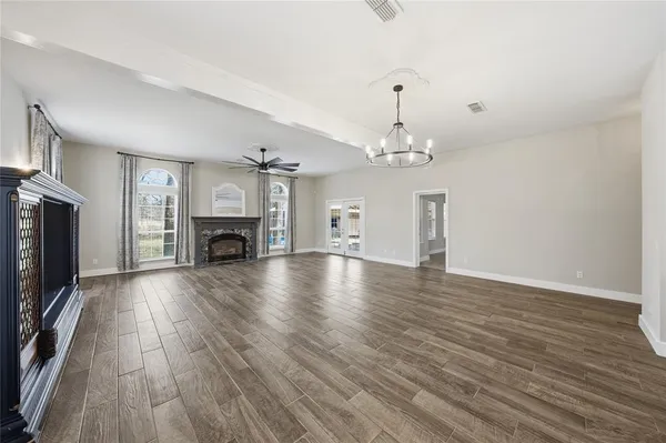 a view of a livingroom with fireplace a chandelier and wooden floor