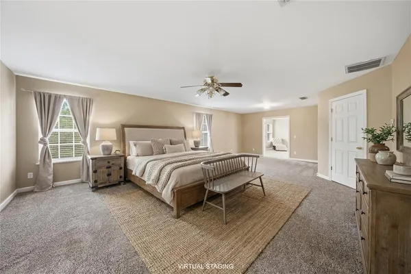 a spacious bedroom with a bed and glass door