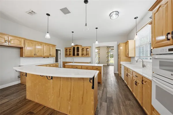 a large kitchen with stainless steel appliances kitchen island granite countertop a large island in the center