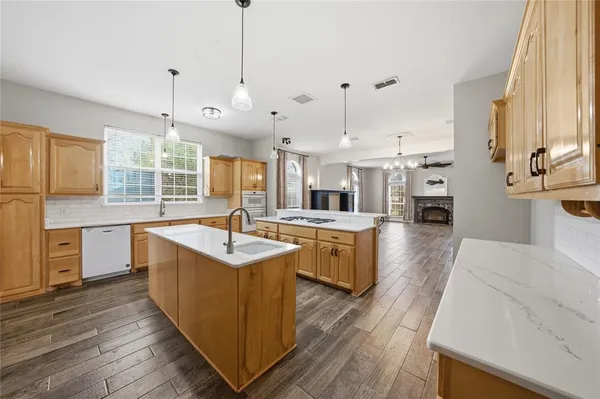 a kitchen with stainless steel appliances granite countertop a sink stove and wooden floor