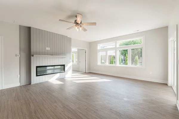 a view of an empty room with a window and fireplace