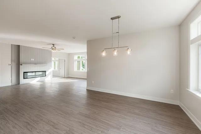 a view of an empty room with window and wooden floor