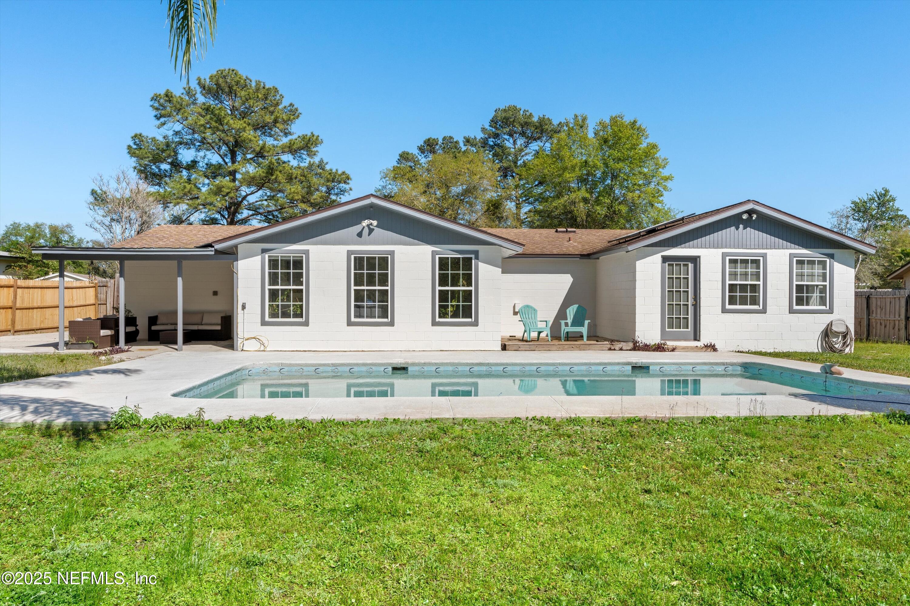 a front view of a house with a yard patio and swimming pool