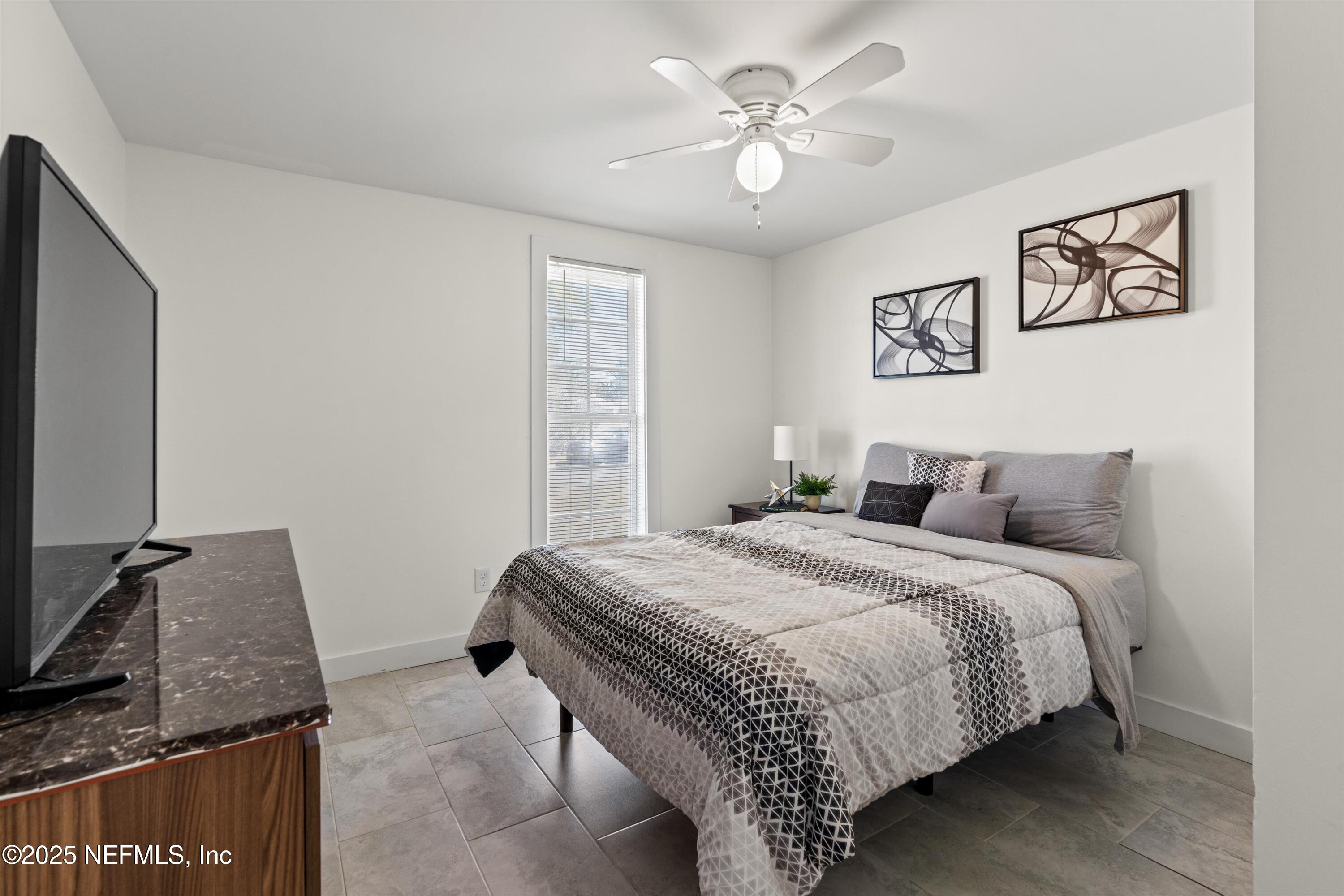 1216 Tumbleweed Drive Orange Park, FL 32065 - Photo 24 of 38 a bedroom with a bed and a flat screen tv