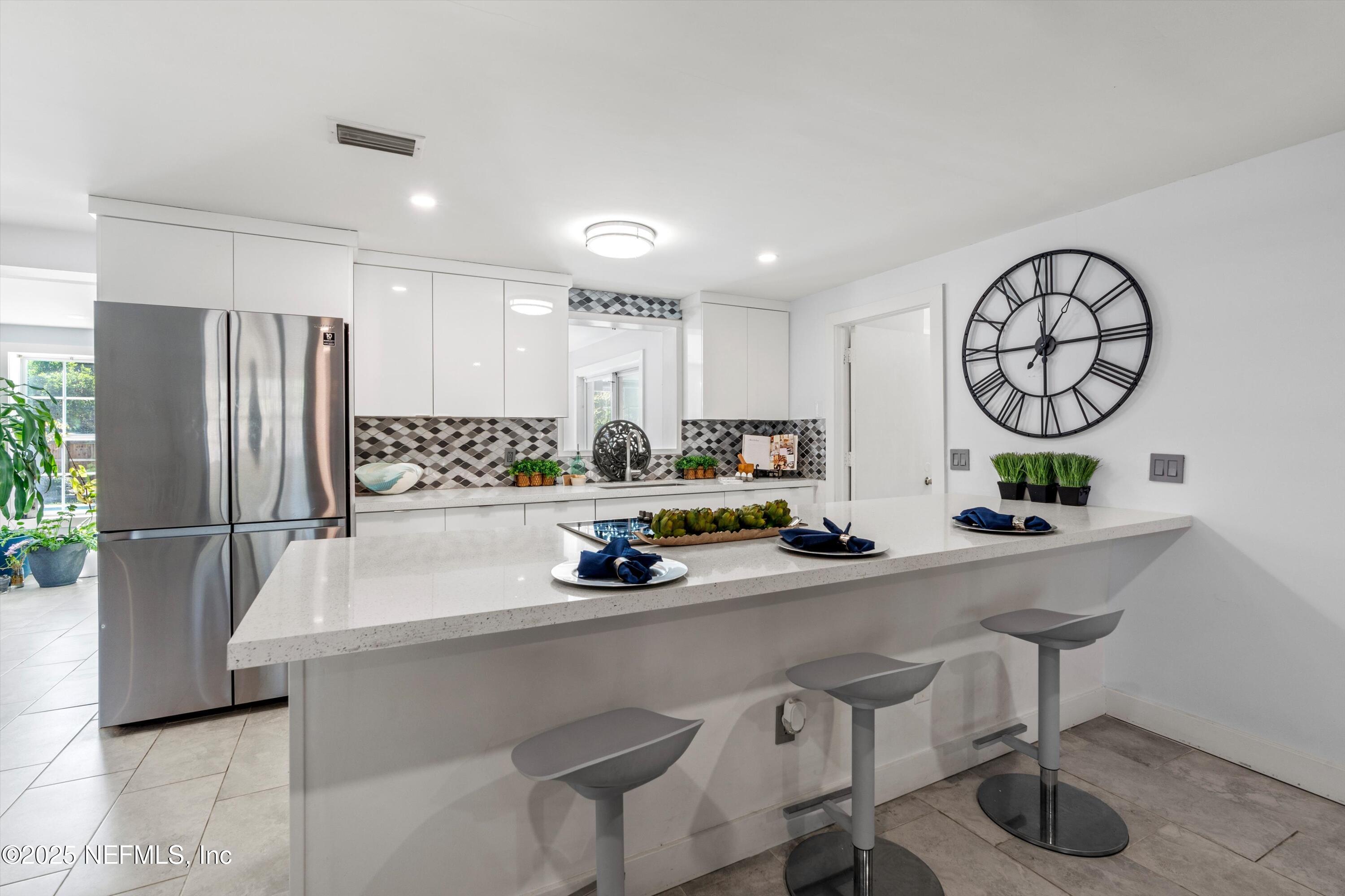 1216 Tumbleweed Drive Orange Park, FL 32065 - Photo 10 of 38 a kitchen with a sink a refrigerator and cabinets
