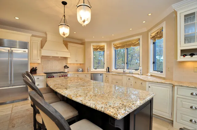 a kitchen with granite countertop kitchen island a table and a sink