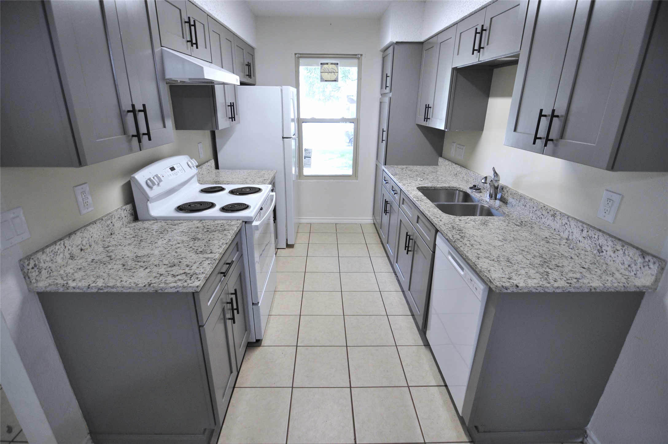8809 Piney Point Drive, Unit B Austin, TX 78729 - Photo 5 of 10 Step into a well-appointed kitchen featuring sleek gray cabinetry and granite countertops.