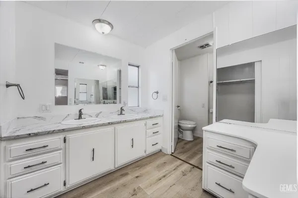 a bathroom with a granite countertop sink mirror and toilet
