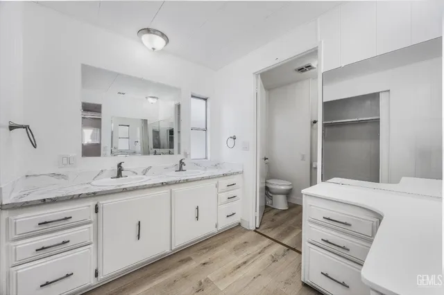a bathroom with a granite countertop sink mirror and toilet