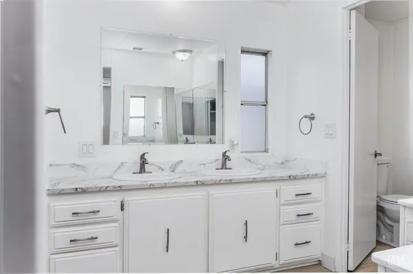 a bathroom with a granite countertop sink and a mirror
