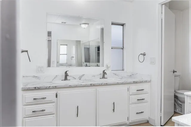 a bathroom with a granite countertop sink and a mirror