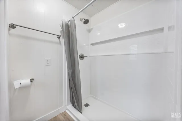 a bathroom with a shower and a glass door